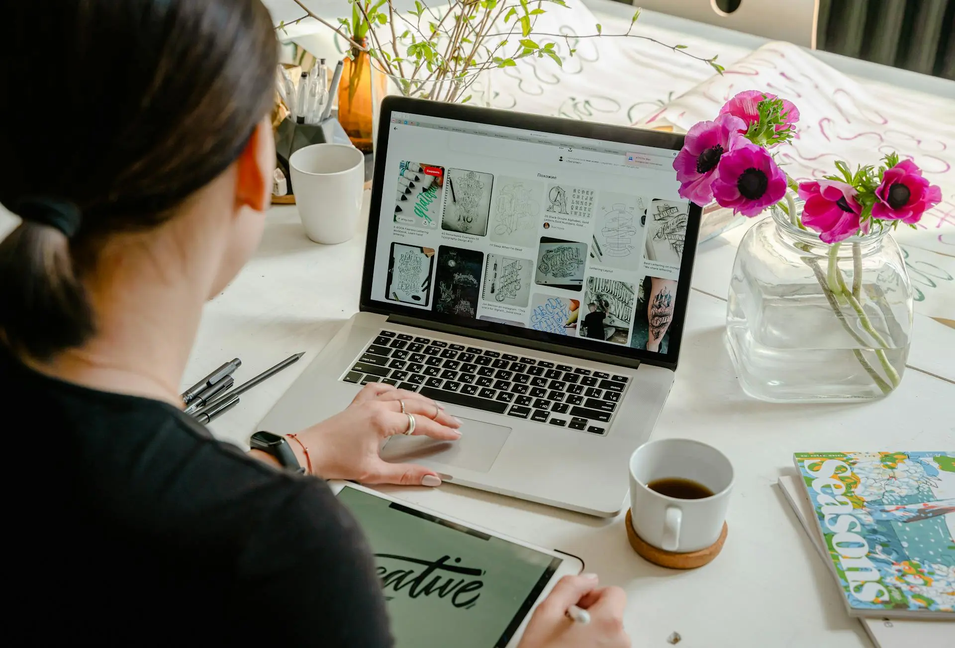 Designer working on laptop and tablet at desk