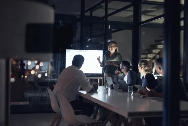 Business presentation in modern office at night.