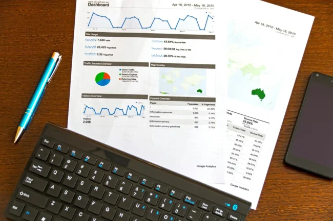 Web analytics dashboard printed papers with pen and keyboard.