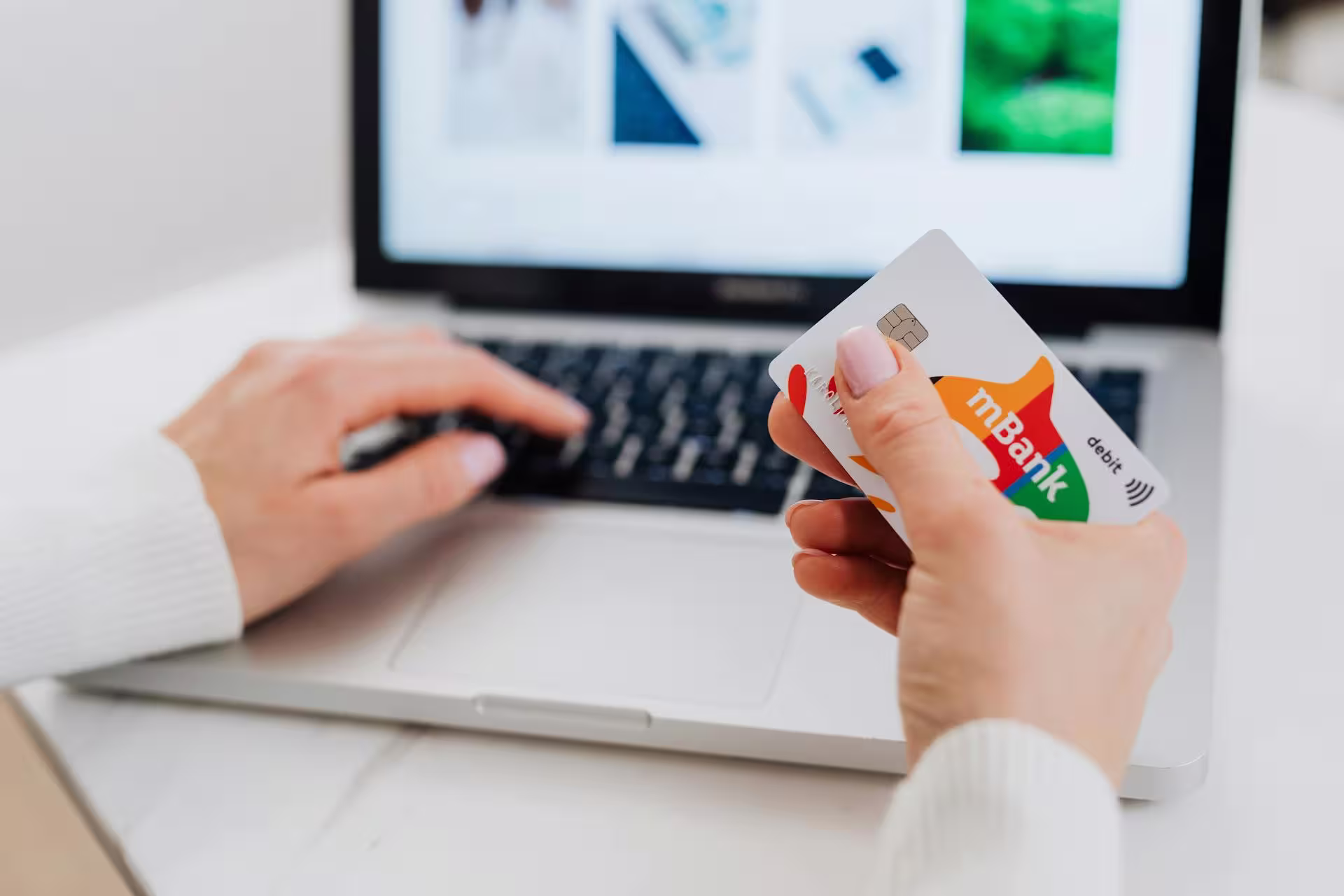 Picture of laptop and woman about to make an online payment.