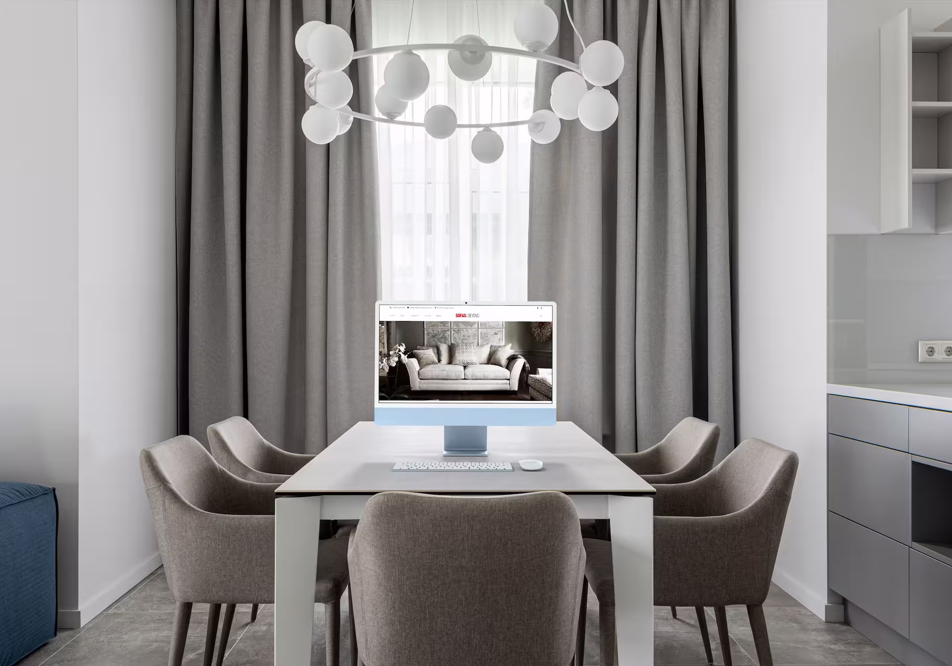 An elegant room with a computer on a table showing a website.